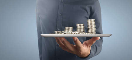 Coin and wealth concept. Loads of money on glass representing tabletの写真素材