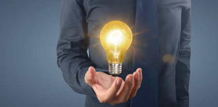 Hand of holding illuminated light bulb, idea, innovation inspiration conceptの写真素材