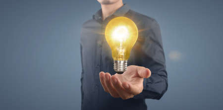 Hand of holding illuminated light bulb, idea, innovation inspiration conceptの写真素材