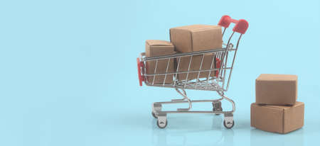 Toy shopping cart with boxes shopping and delivery concept. Consumer society trendの写真素材