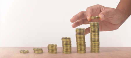 Stack coin in hand with trading graph, financial investment conceptの写真素材