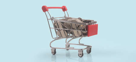 Toy shopping cart with coins and Consumer society trendの写真素材