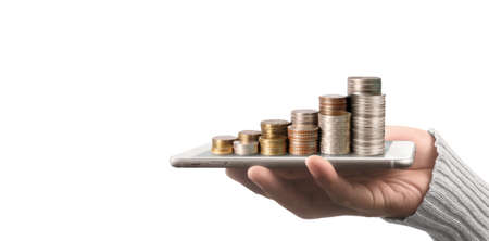 Coin and wealth concept. Loads of money on glass representing digital tabletの写真素材