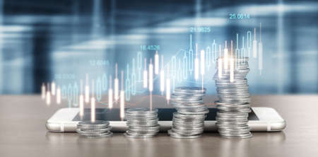 smartphone screen next to growing piles of coins and chart positive indicators in his businessの写真素材