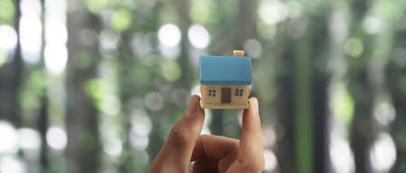 Hand holding  house model. property insurance and security Buy and rent house conceptの写真素材
