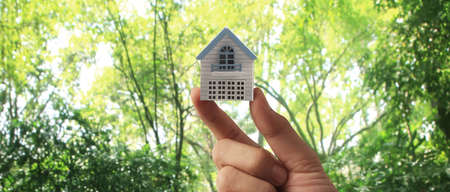 Hand holding  house model. property insurance and security Buy and rent house conceptの写真素材