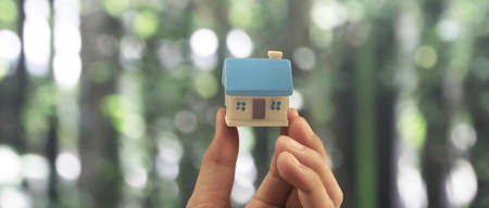 Hand holding  house model. property insurance and security Buy and rent house conceptの写真素材