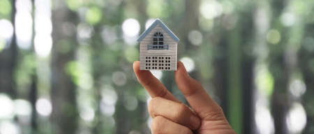 Hand holding  house model. property insurance and security Buy and rent house conceptの写真素材