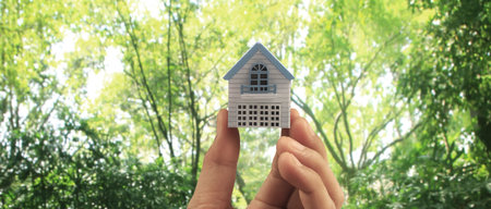 Hand holding  house model. property insurance and security Buy and rent house conceptの写真素材