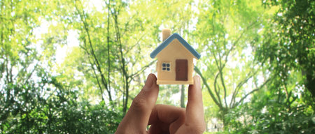 Hand holding  house model. property insurance and security Buy and rent house conceptの写真素材