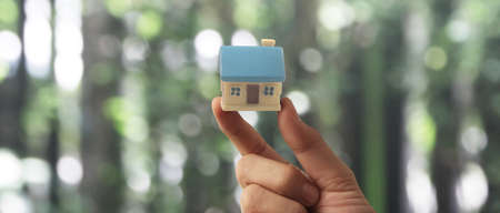 Hand holding  house model. property insurance and security Buy and rent house conceptの写真素材