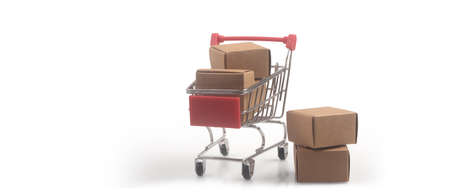Toy shopping cart with boxes shopping and delivery concept. Consumer society trendの写真素材