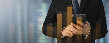 Businessman plan graph growth and increase of chart positive indicators in his business on smartphoneの写真素材