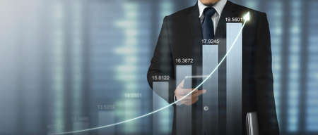 Mand holding smartphone device and touching screen. Stock exchange market concept. Trader looking on with graphs analysis candleの写真素材