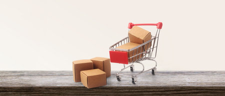Toy shopping cart with boxes shopping and delivery concept. Consumer society trendの写真素材