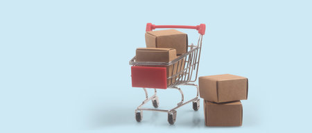Toy shopping cart with boxes shopping and delivery concept. Consumer society trendの写真素材