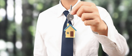 Real estate agent handing over a house keys in handの写真素材