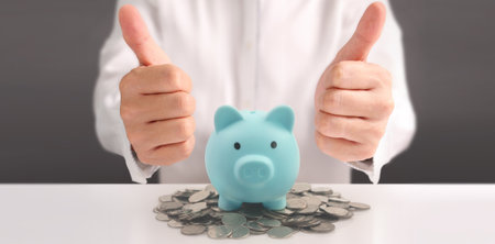 Man hand put coin money to piggy bank, saving and deposit money conceptの写真素材