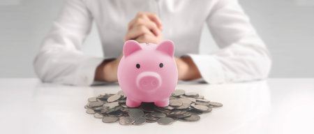 Man hand put coin money to piggy bank, saving and deposit money conceptの写真素材