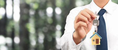 Real estate agent handing over a house keys in handの写真素材