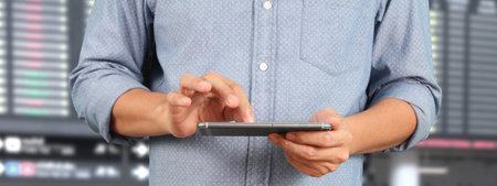 Man holding smartphone in hand device and touching screenの写真素材