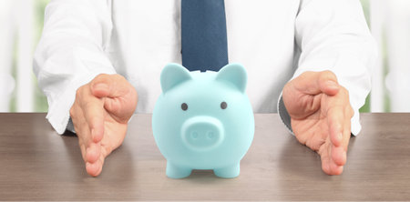 Man hand put coin money to piggy bank, saving and deposit money conceptの写真素材