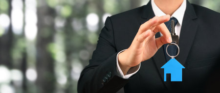 Real estate agent handing over a house keys in handの写真素材