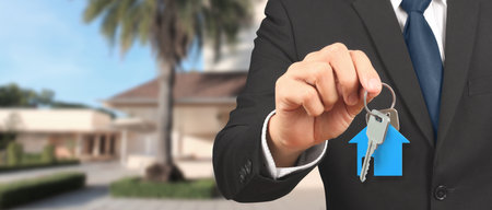 Real estate agent handing over a house keys in handの写真素材