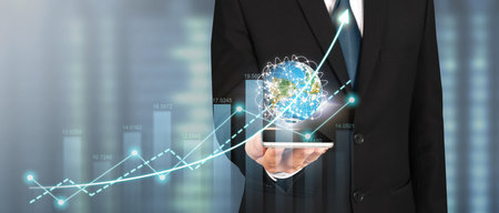 Hand holding smartphone device and touching screen. Stock exchange market concept.Trader looking onの写真素材