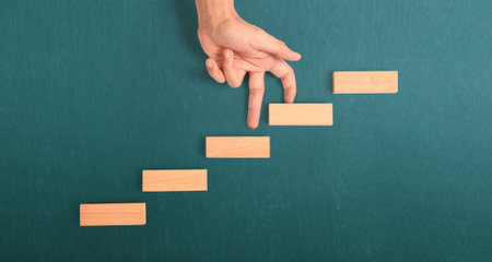 Hand liken person stepping up a toy staircase woodの写真素材