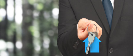 Real estate agent handing over a house keys in handの写真素材