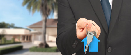 Real estate agent handing over a house keys in handの写真素材