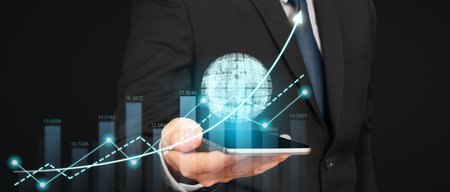 Hand holding smartphone device and touching screen. Stock exchange market concept.Trader looking onの写真素材