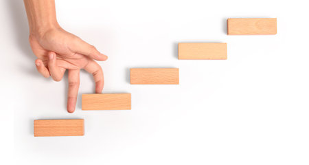 Hand liken person stepping up a toy staircase woodの写真素材