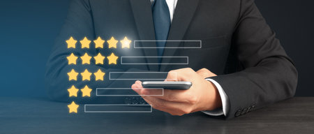 Man holding smartphone device and touching screen with five star rating feedback iconの写真素材