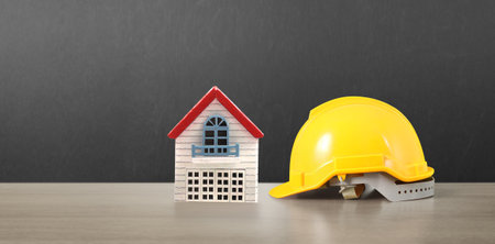 Yellow hardhat model house and coin with trading graph, financial investment conceptの写真素材