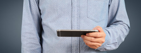 Man holding smartphone device and touching screenの写真素材
