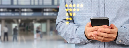 Man holding smartphone device and touching screen with five star rating feedback iconの写真素材