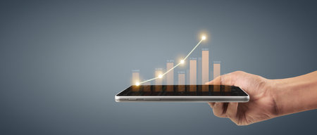 Plan graph growth and increase of chart positive indicators in his business,tablet in handの写真素材
