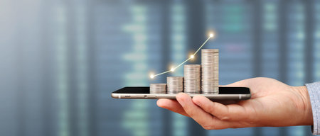 Hand holding smartphone device and touching screen. Stock exchange market concept.Trader lookingの写真素材