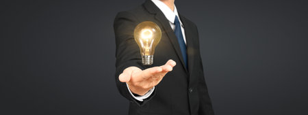 Humans hold light bulbs in hand innovative technology and creativityの写真素材