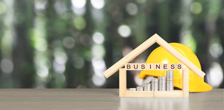 Yellow hardhat model house and coin with trading graph, financial investment conceptの写真素材