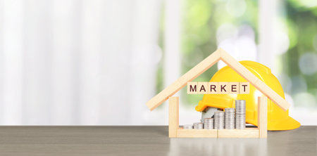 Yellow hardhat model house and coin with trading graph, financial investment conceptの写真素材