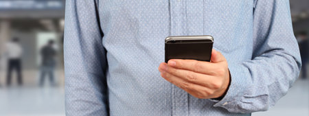 Man holding smartphone device and touching screenの写真素材