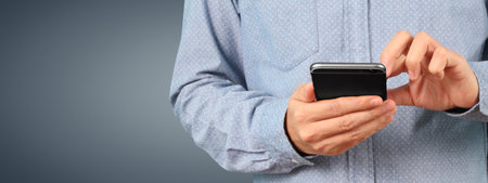 Man holding smartphone device and touching screenの写真素材