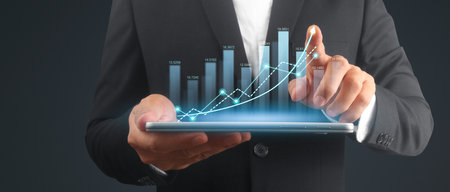 Businessman plan graph growth and increase of chart positive indicators in his business,tablet in handの写真素材