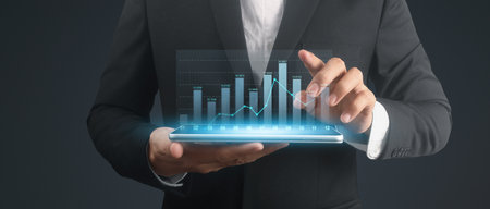 Businessman plan graph growth and increase of chart positive indicators in his business,tablet in handの写真素材
