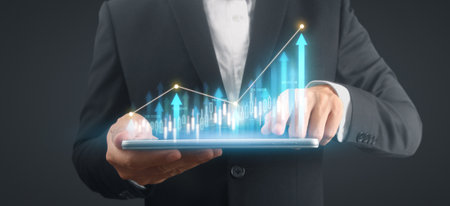 Businessman plan graph growth and increase of chart positive indicators in his business,tablet in handの写真素材