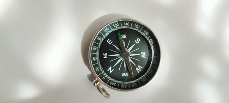 Exploring directional navigation with a compass outdoors equipment close-up natural light ground level adventure conceptの写真素材