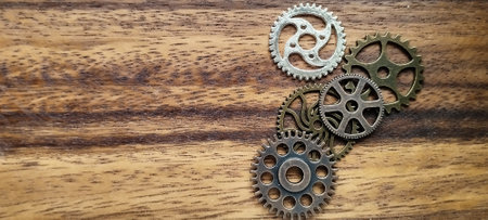 Exploring mechanical gears arrangement on wood surface close-up still life industrial environment abstract conceptの写真素材